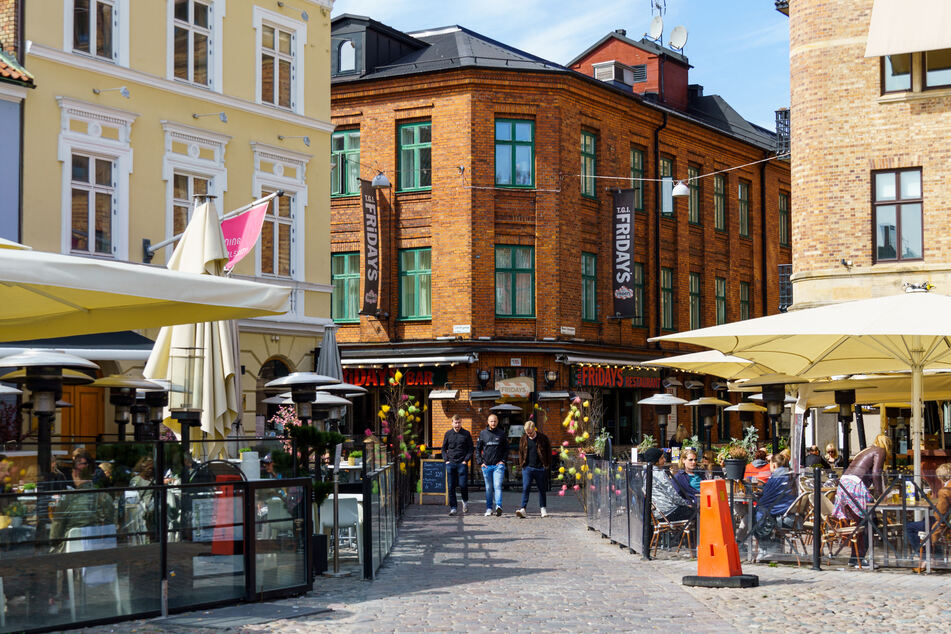 Die Menschen sitzen in Restaurants und Cafés auf Lilla Torg Platz in der Sonne. Der schwedische Sonderweg in der Bekämpfung des Corona-Virus hat einen hohen Preis.