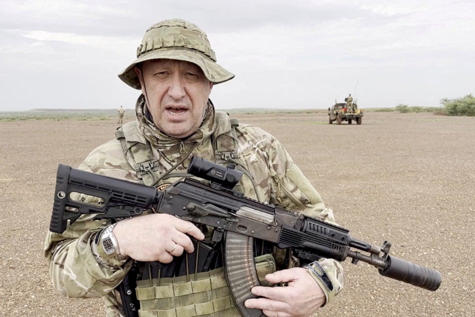 Yevgeny Prigozhin gives an address in camouflage and with a weapon in his hands in a desert area at an unknown location on August 21, 2023.