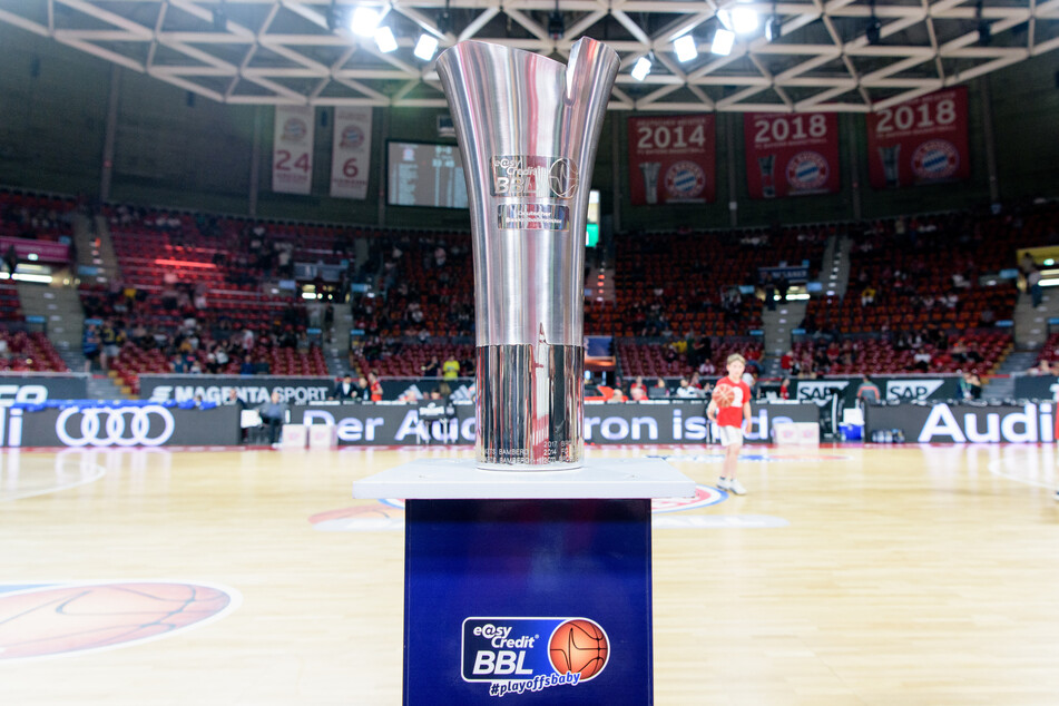 Der Ligapokal der Deutschen Basketball Bundesliga steht vor Spielbeginn auf einem Podest am Spielfeldrand. (Archivbild)