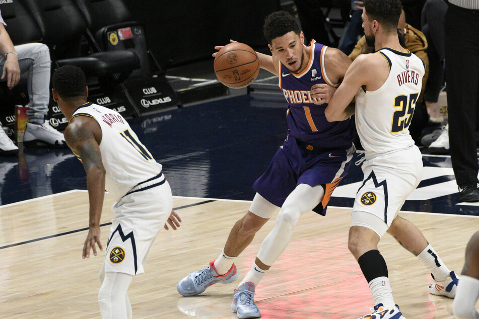 Devin Booker (c.) posted a season-high 49 points against the Nuggets.
