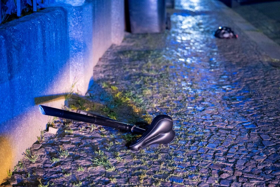 Bilder von vor Ort zeigen einen Sattel und einen Fahrradhelm, die auf dem Fußweg liegen.