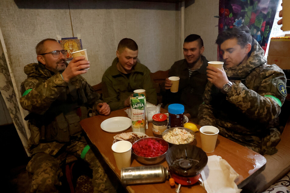 Soldiers from the 80th Separate Air Assault Brigade celebrate with a toast over Orthodox Christmas at dinner in their rest house, during a ceasefire announced by Russia over the Orthodox Christmas period, from the frontline region of Kreminna, Ukraine.
