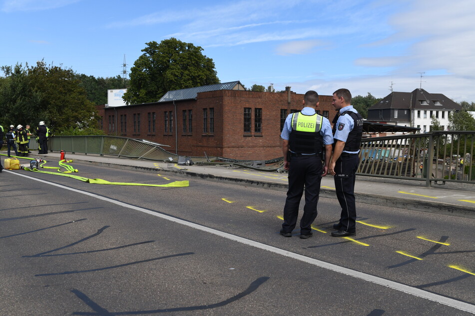 Der Laster hatte zuvor die Leitplanken auf der Brücke durchbrochen. Die Polizei sicherte die Unfallstelle ab.