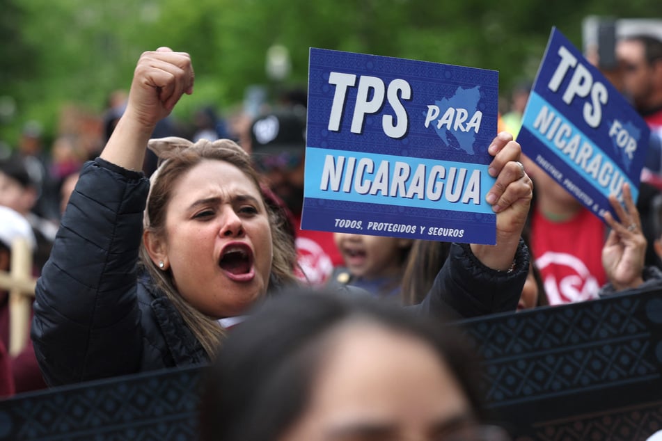 Immigrants' rights activists hold signs reading "TPS for Nicaragua" during a demonstration in Washington DC.