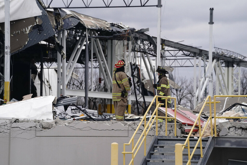 Firefighters survey the twisted metal at the Amazon hub in Edwardsville, Illinois, on December 11.