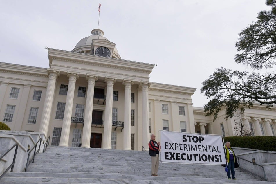 Protestors against the death penalty gather at the state Capitol building in Montgomery, Alabama, holding a banner reading "Stop Experimental Executions!"