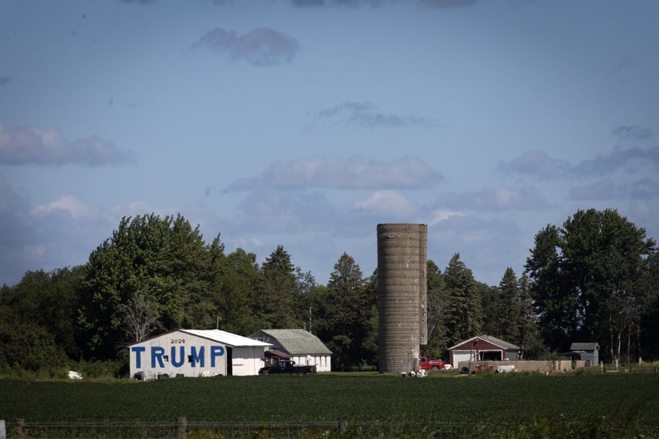 A farmer paints a barn to show support for then Republican presidential candidate Donald Trump in August 2024 near Charles City, Iowa.