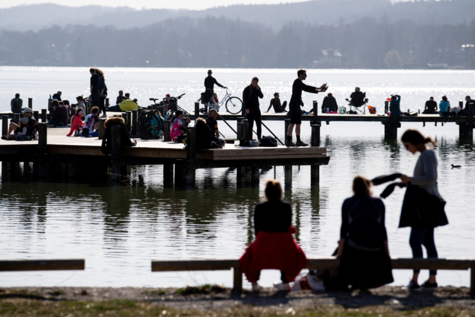 Zahlreiche Menschen genießen am Starnberger See das schöne Wetter auf einem Steg. (Symbolbild)