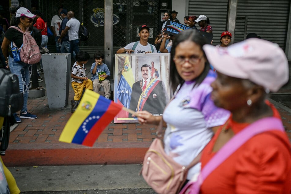 A supporter of Venezuela's President Nicolas Maduro holds a portrait of him during a protest in Caracas on August 11, 2025.