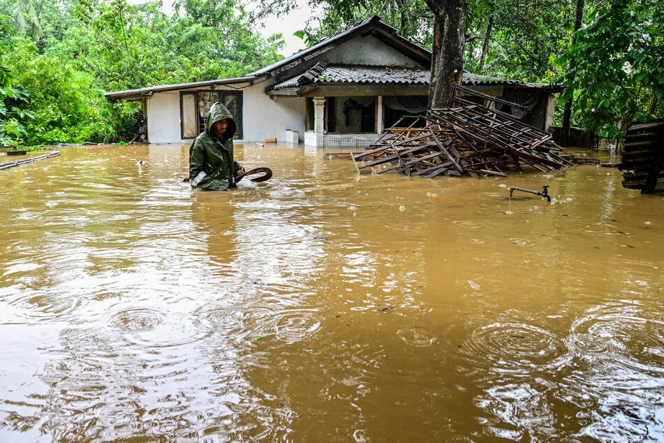 Ein Mann kämpft sich durch die Wassermassen vor seinem Haus in Kaduwela.