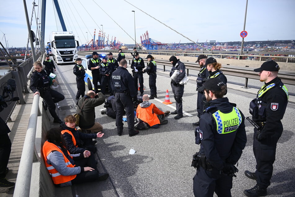 Aktivisten der Gruppe "Letzte Generation" auf der Hamburger Köhlbrandbrücke am Dienstag. Der Kipplaster mit Kies ist auf dem Foto nicht zu sehen.