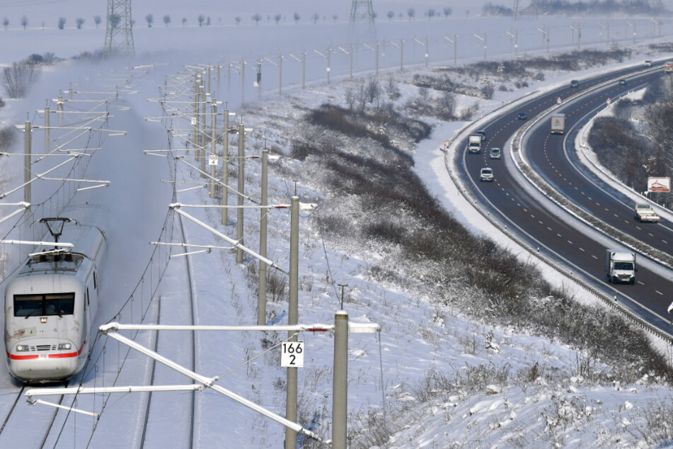 Schnee, wohin das Auge reicht. Ein ICE fährt bei Arnstadt auf der Strecke zwischen Berlin und München entlang der Autobahn A71.