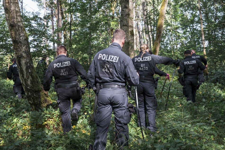 Polizisten durchkämmen den Wald im Landkreis Forchheim nach Hinweisen.