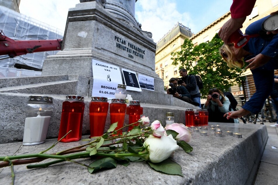 Mourners light candles at a makeshift memorial a day after a deadly school shooting in Belgrade, Serbia.