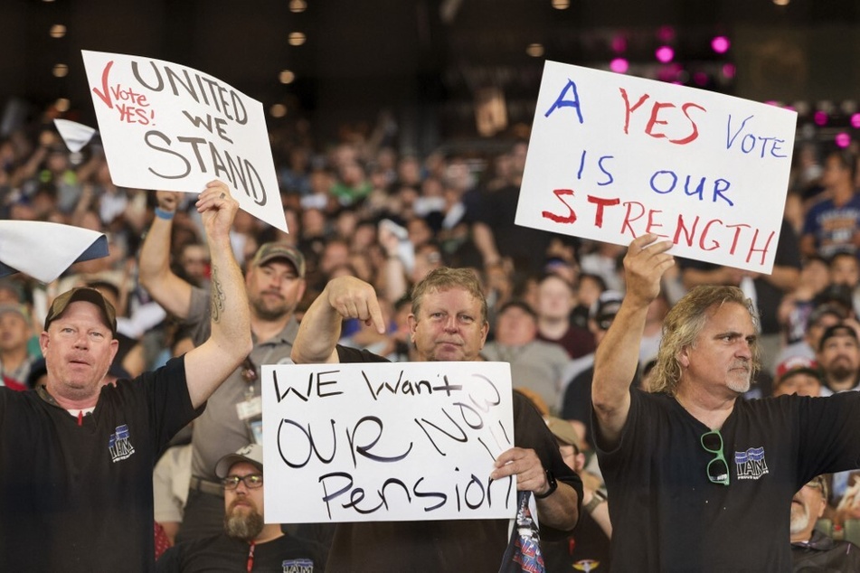 People hold signs for a "yes" vote as members and supporters of the International Association of Machinists and Aerospace Worker Union District 751 attend an early strike-sanction vote event.