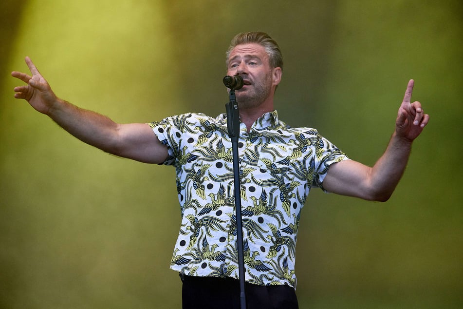 Der Sänger Sasha (49) steht auf der Bühne des Strandkorb-Open-Air-Konzerts am Cruise Center Steinwerder.