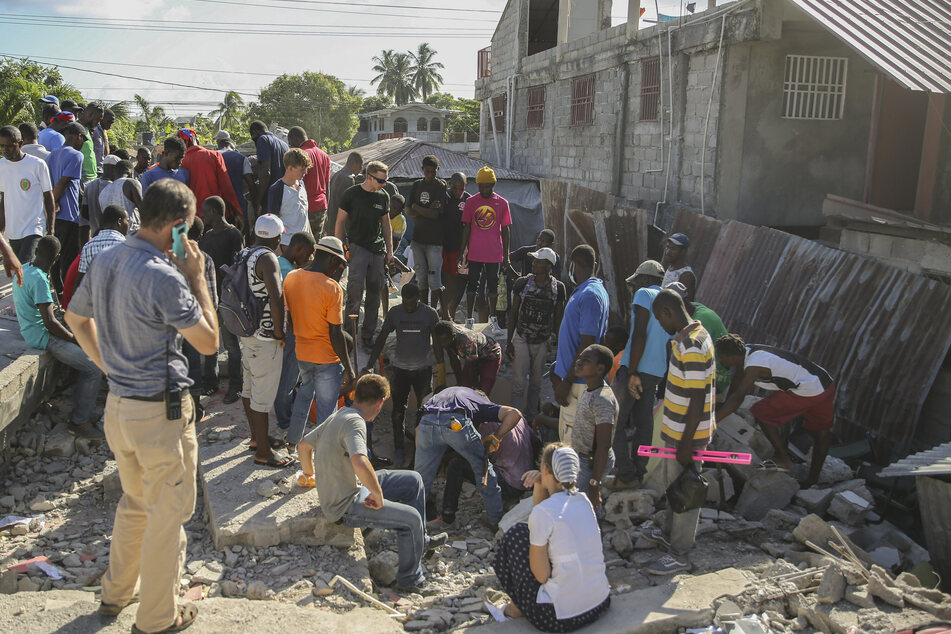 Menschen suchen nach Überlebenden in einem vom Erdbeben zerstörten Haus in Les Cayes, Haiti.