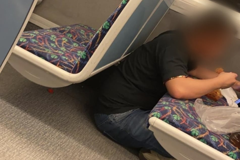 Der Hunger war wohl zu groß: Der Pendler nimmt seine Mahlzeit statt zu Hause am Tisch lieber auf dem Sitz eines Zuges ein.