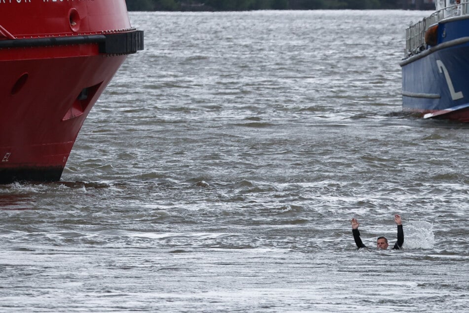 Ein Taucher der Feuerwehr Hamburg schwimmt in der Elbe vor Teufelsbrück.