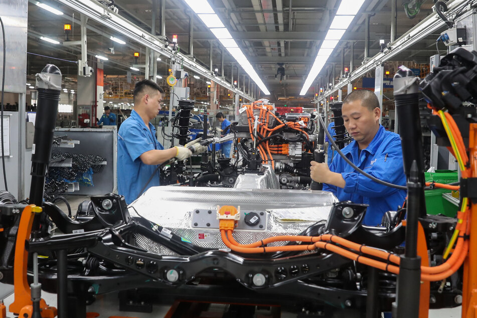 China, Shanghai: Fahrzeugbauer arbeiten in einer Werkshalle in einer Produktionslinie von SAIC Volkswagen. Die Auswirkungen der Corona-Krise ziehen sich für deutsche Unternehmen in China länger hin als erwartet.