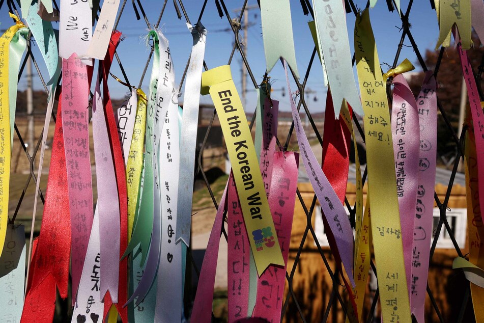 Ribbons wishing for peace hang on a military fence separating the two Korea.