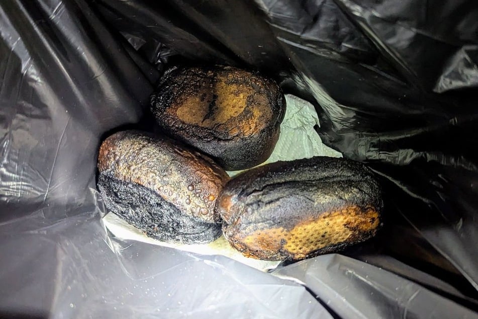 Als die Feuerwehrleute die verrauchte Wohnung durchsuchten, fanden sie drei verkohlte Brötchen in der Mikrowelle.
