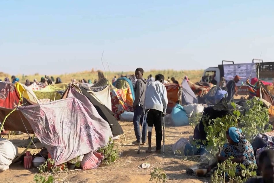 Displaced people gather and sit in makeshift tents in Tawila, Sudan, after fleeing El-Fasher city in Darfur, on October 29, 2025.