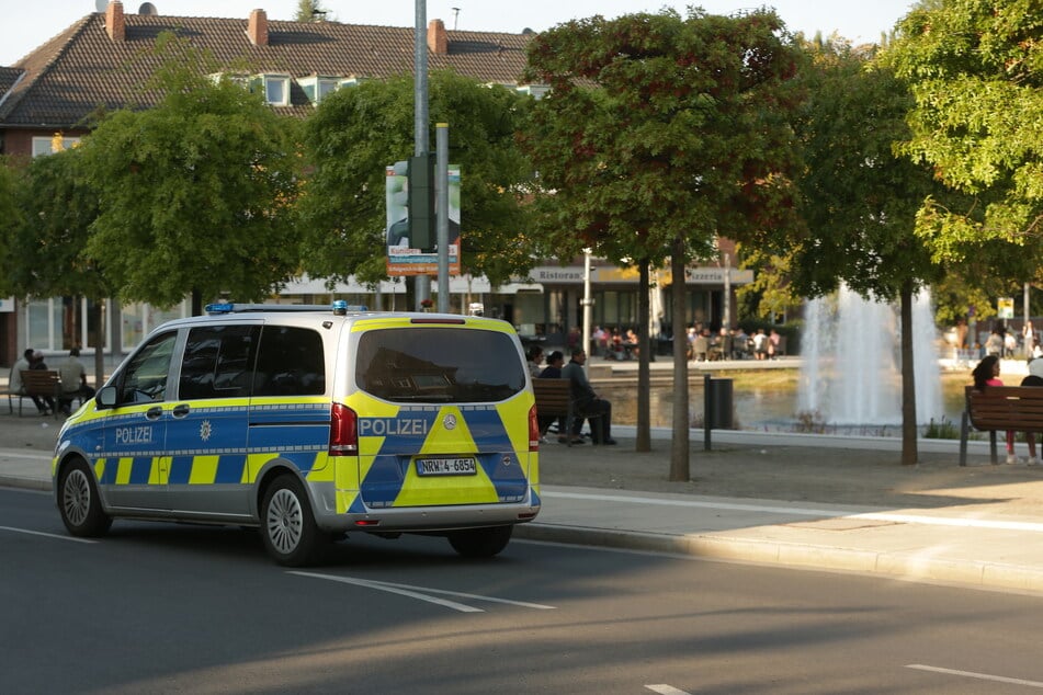 Ein Polizei Fahrzeug fährt am Bastinsweiher im Ortskern von Stolberg vorbei. Nach einer mutmaßlich islamistisch motivierten Attacke in dem Ort bei Aachen ist ein Verdächtiger festgenommen worden.