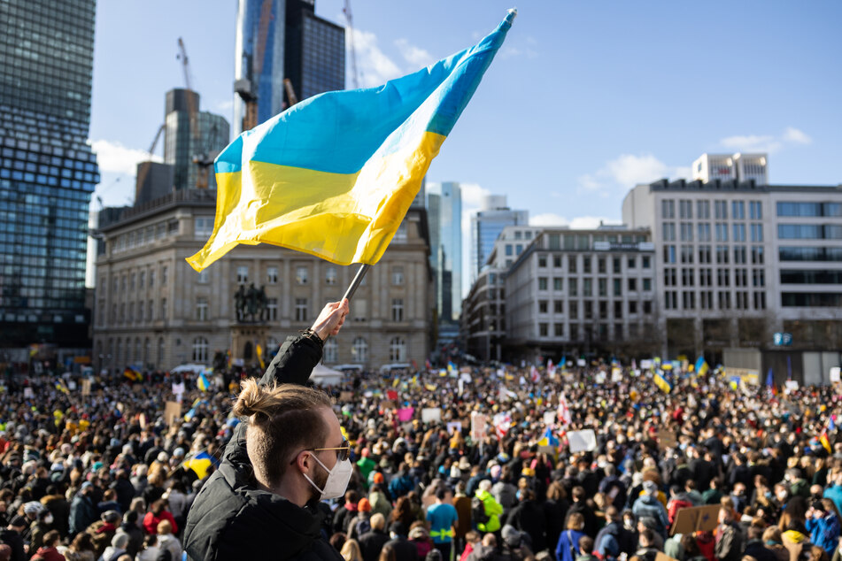 Ein Demonstrant schwenkt auf der Veranstaltung "Solidarität mit der Ukraine - Frieden in Osteuropa" von Bündnis 90/Die Grünen am Rathenauplatz eine ukrainische Flagge.