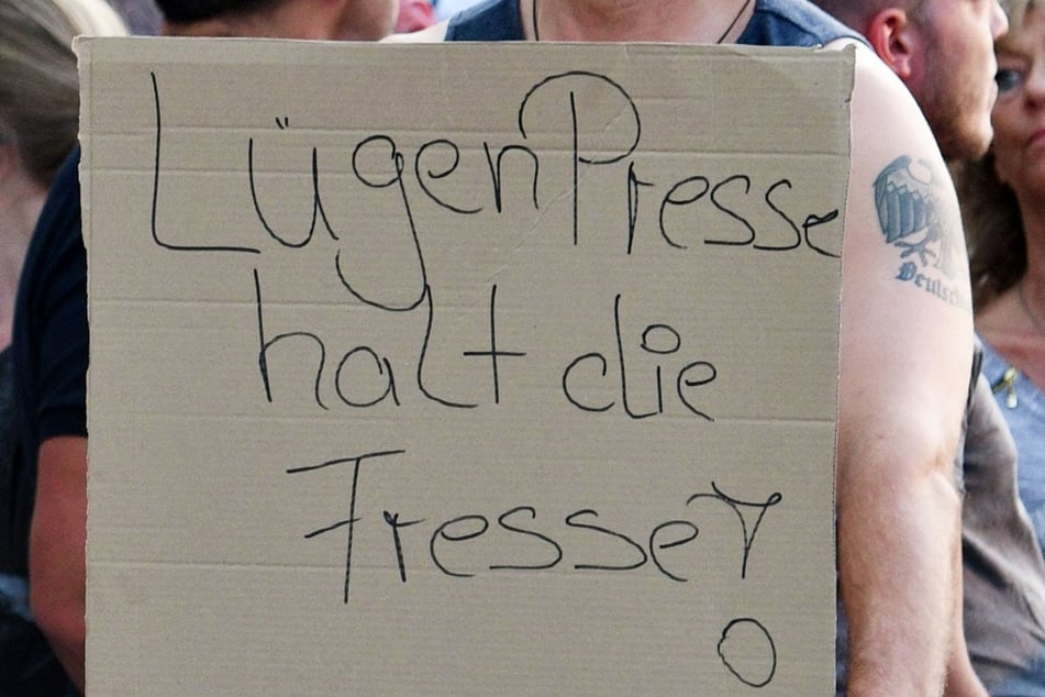 Ein Teilnehmer einer Kundgebung rechter Gruppen in Köln zeigt ein Schild mit der Aufschrift "LügenPresse halt die Fresse!".