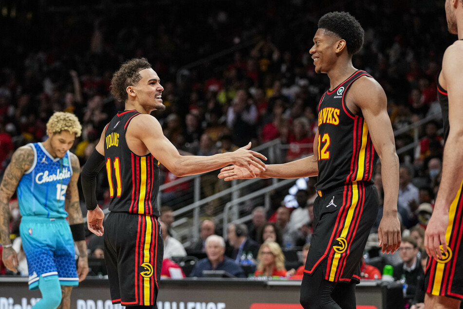 Trae Young (l.) and De'Andre Hunter celebrate during the Hawks' win over the Hornets.