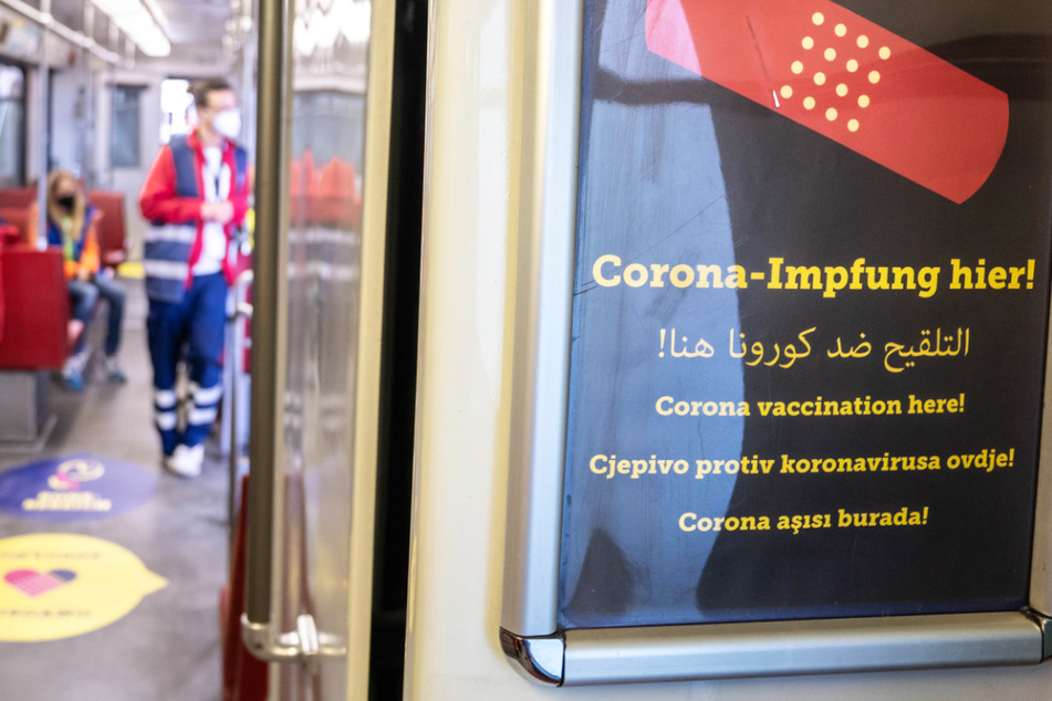 "Corona-Impfung hier" steht in mehreren Sprachen auf einem Schild in einer umgerüsteten Straßenbahn bei der offiziellen Vorstellung des "Impf-Express".