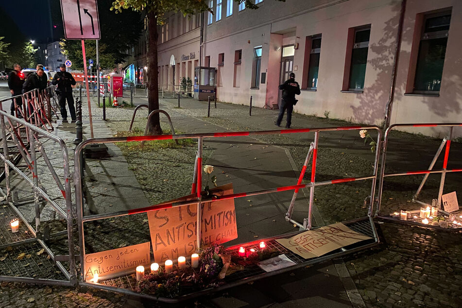 Brennende Kerzen und ein Schild mit der Aufschrift "Stoppt Antisemitismus" erinnern an den Anschlagsversuch.