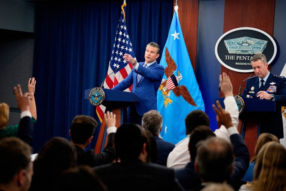 Defense Secretary Pete Hegseth (c.) and Joint Chiefs of Staff Air Force Gen. Dan Caine (r.) take a question from a reporter during a news conference at the Pentagon on June 26, 2025.
