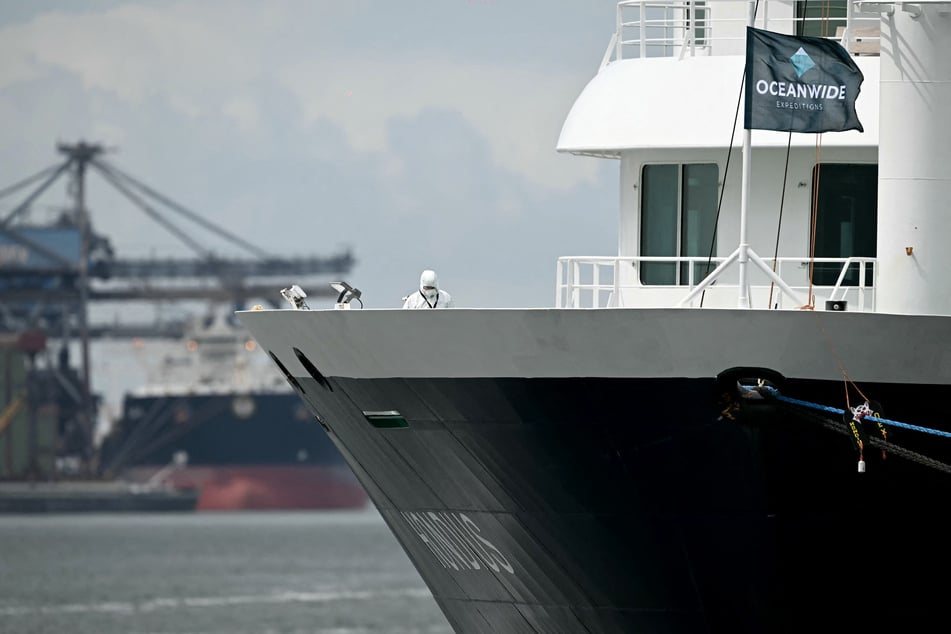 A person in a protective suit inspects the Dutch Hantavirus-hit cruise ship MV Hondius after arriving at the port of Rotterdam on May 18, 2026.