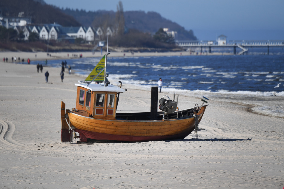 Spaziergänger sind am Strand von Ahlbeck auf der Insel Usedom unterwegs.