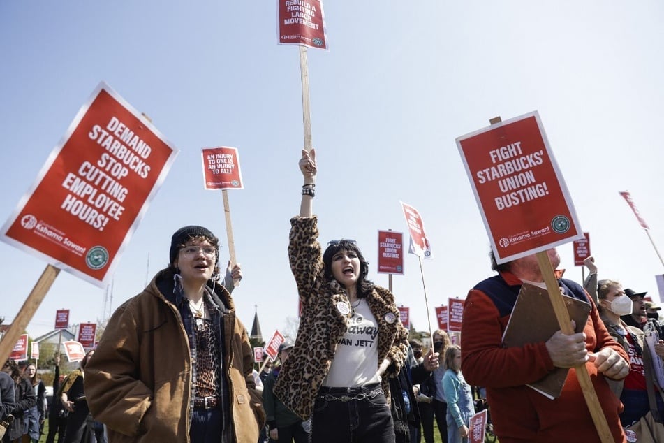 Starbucks Workers United members and supporters raise picket signs during the "Fight Starbucks' Union Busting" rally and march in Seattle, Washington.