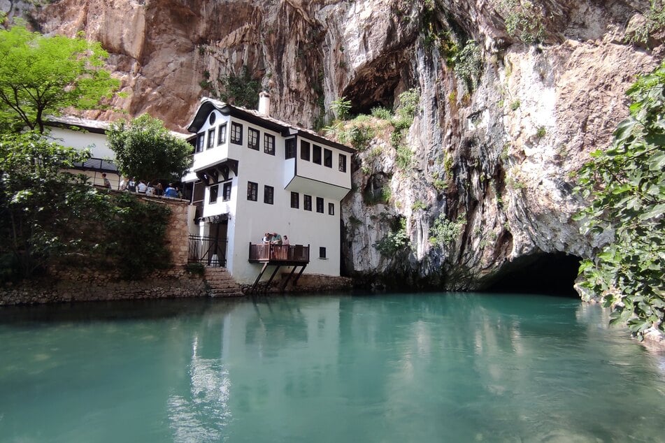 Kultur trifft auf Schönheit: Das historische Kloster Blagaj in Bosnien und Herzegowina liegt romantisch an einem eiskalten Bergfluss, umgeben von hohen Steinfelsen.