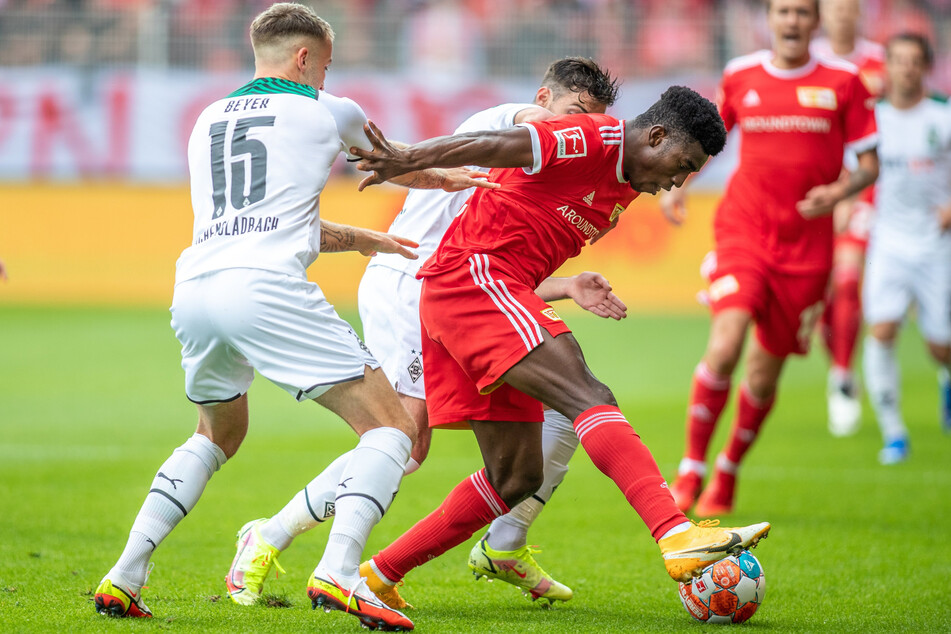 Union-Angreifer Taiwo Awoniyi (24, 3.v.l.) behauptet gegen die beiden Gladbacher Jordan Beyer (21, l.) und Joe Scally (18, verdeckt) den Ball.