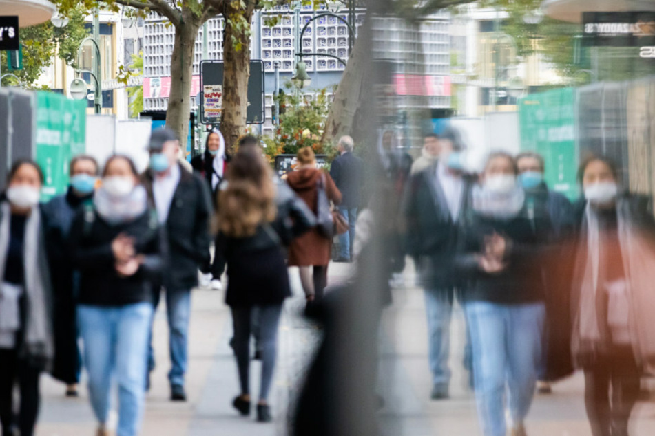 Passanten mit Mund-Nasen-Schutz gehen auf der Tauentzienstraße.