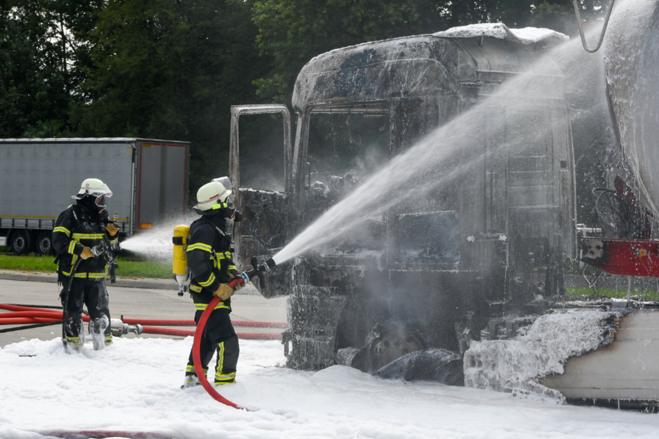 Feuerwehrleute kämpfen löschen das Fahrzeug mit Schaum.