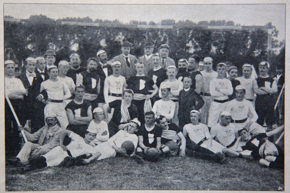 Die älteste Fotografie einer Dresdner Fußballmannschaft. An jenem 4. August 1895 spielt Dresden gegen Berlin - ein Klassiker eben. Auffällig: Die Spieler tragen knielange Hosen und armlange Hemden mit Emblem, dazu Kappen auf dem Kopf.