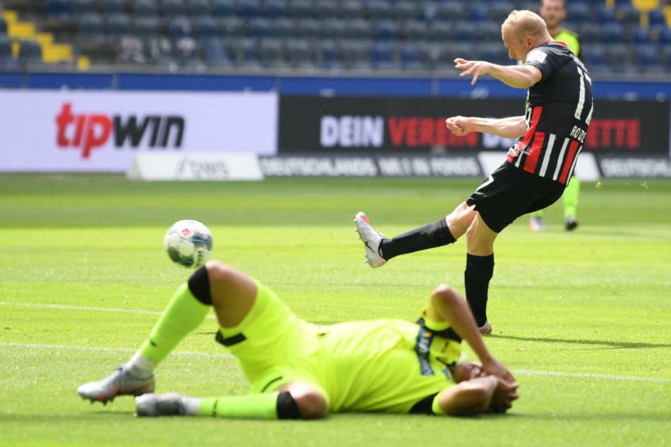 Paderborns Abdelhamid Sabiri liegt nach seinem Zusammenstoß mit einem Mitspieler auf dem Boden, während Sebastian Rode das 1:0 für Eintracht Frankfurt schießt.