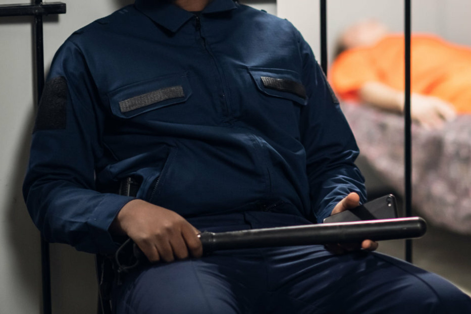 Ein Polizist bewacht einen Gefangenen in einer Haftanstalt. (Symbolbild)