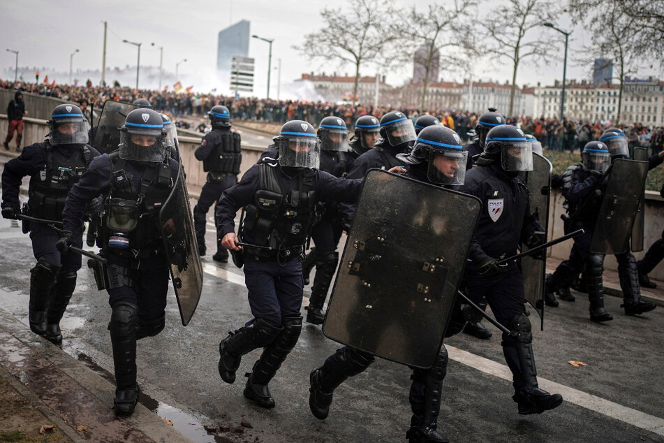 Bereitschaftspolizisten stoßen in Lyon mit Demonstranten zusammen.