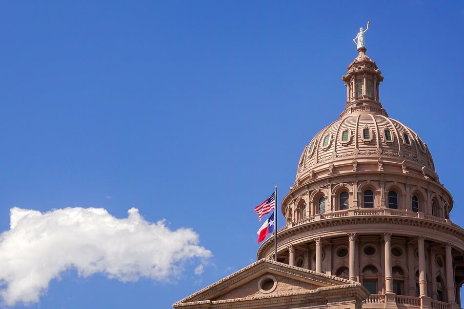 The Texan and US flags fly over the Texas State Capitol in Austin.