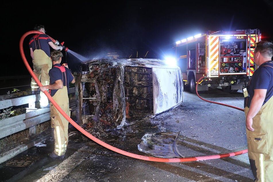 Feuerwehrleute löschen einen Toyota Corolla. Von dem Auto blieb nicht mehr viel übrig.