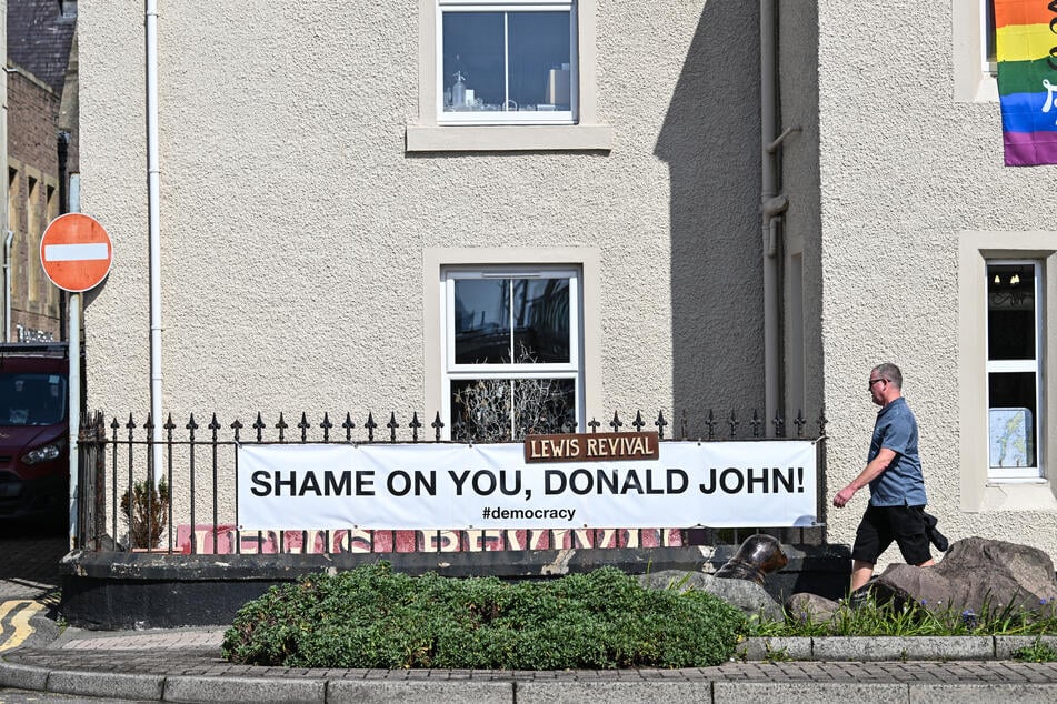 An anti-Donald Trump banner is seen attached to railings on the main South Beach Road in Stornoway, Isle of Lewis, on April 29, 2025.