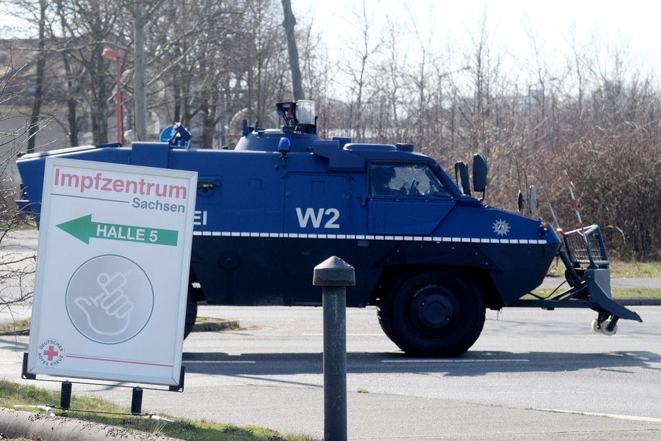 Ein gepanzertes Fahrzeug der Polizei fährt an der Leipziger Messe entlang, in der sich ein Impfzentrum befindet. Dorthin wollten die Autokorsos der Corona-Kritiker ursprünglich fahren.
