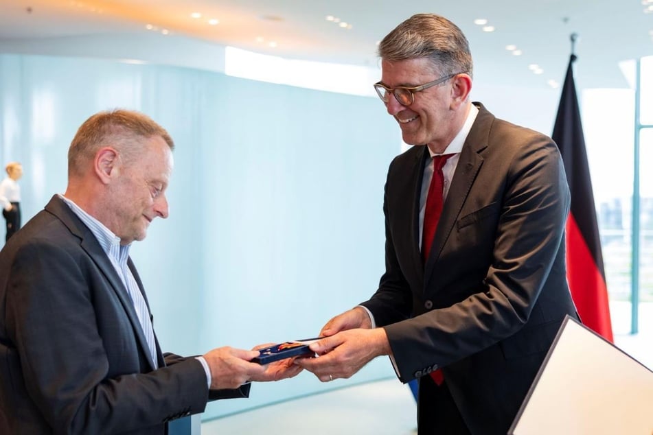 Gilbert Lupfer erhält von Kulturstaatsminister Wolfram Weimer (61) das Bundesverdienstkreuz.